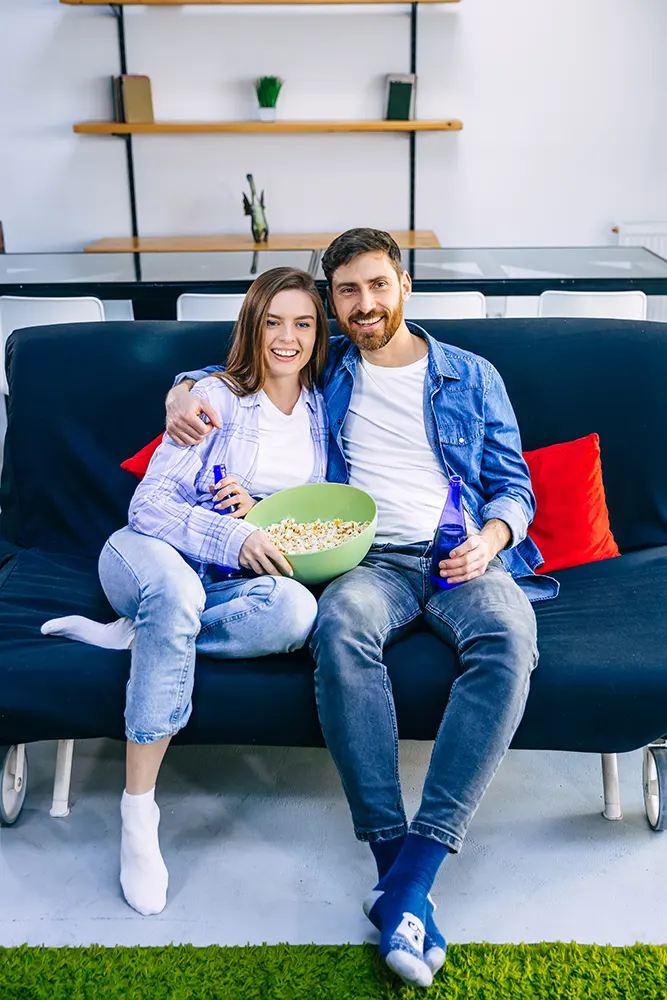 young-handsome-couple-enjoying-free-time-watching-television-with-popcorn